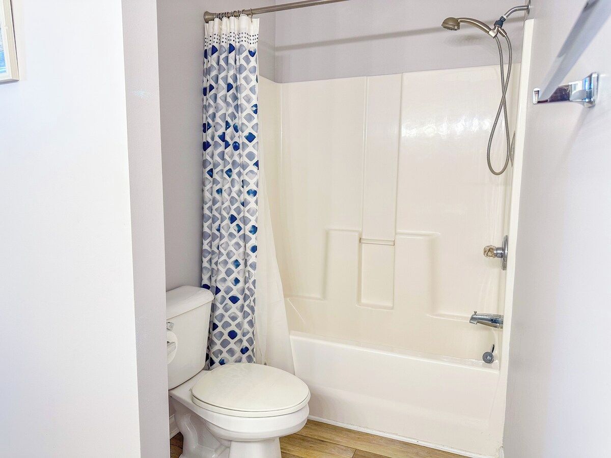 A bathroom with a toilet, a shower, and a bathtub.