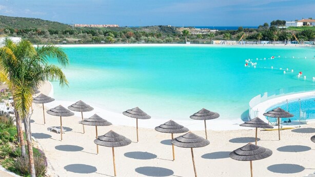 A resort with a large pool, beach umbrellas, and a view of the ocean. - Alcazaba Lagoon  2278 Secret Place (Casares)