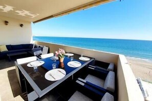 Comedor con una mesa preparada para cuatro, con vistas al océano.