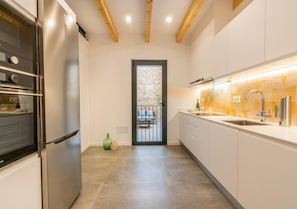 A modern kitchen with stainless steel appliances, a large window, and a view of the outdoors. - Beautiful Mallorcan house with 2 bedrooms, 1 bathroom, pool and barbecue (Campanet)