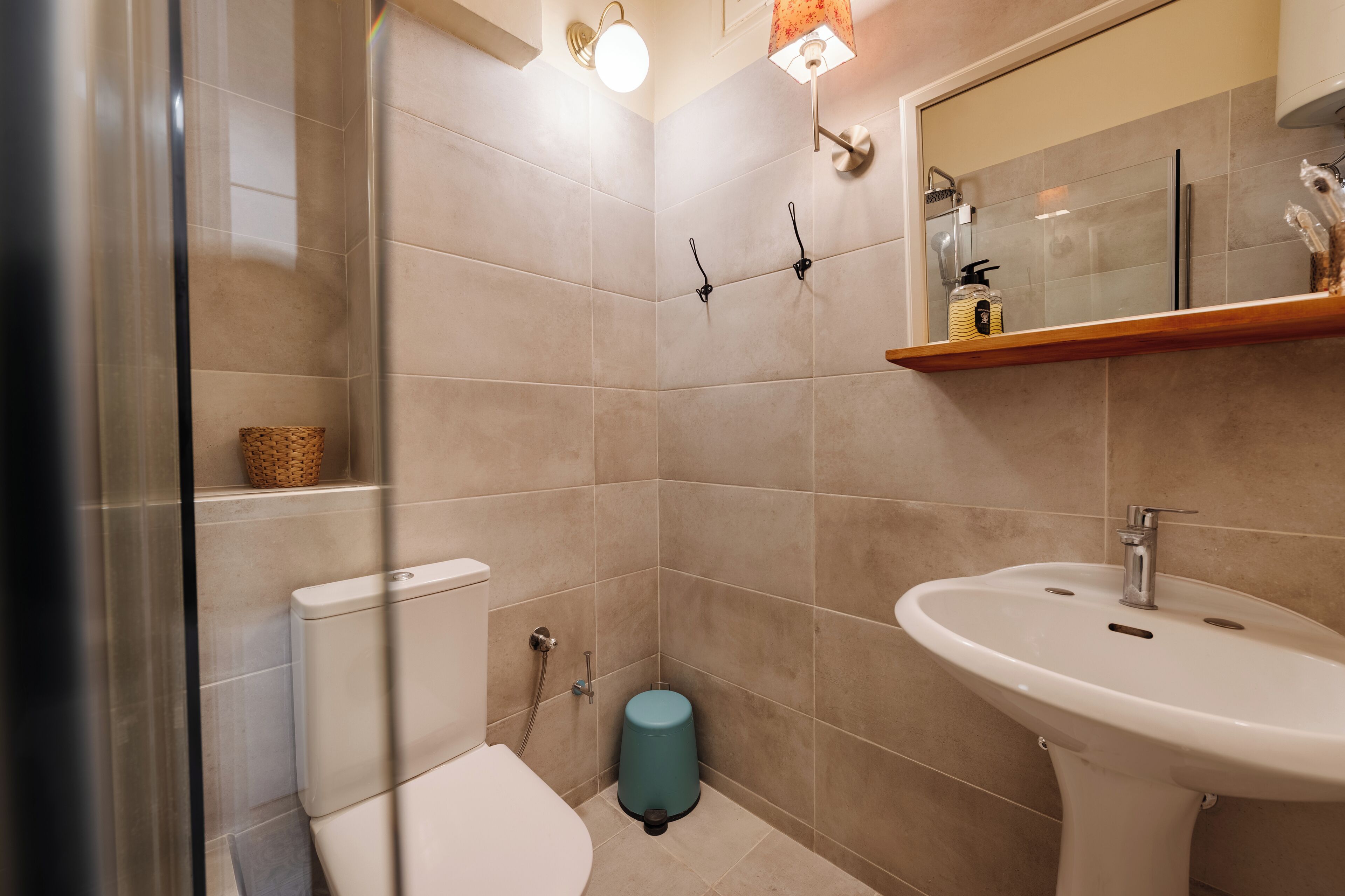 A bathroom with a toilet, bidet, sink, and a mirror.
