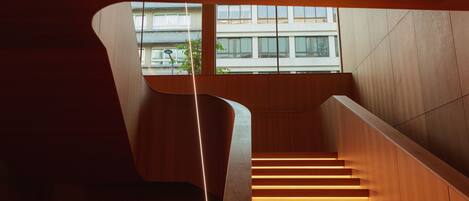 A modern staircase with wooden steps and a curved wall design.
