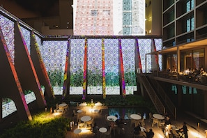 A rooftop terrace with outdoor seating and a decorative wall with vertical light patterns. - Lumen Hotel & The Lisbon Light Show (Lisbon)