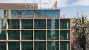 A modern building with the name "LUMEN" on the facade, featuring a grid of windows and balconies.