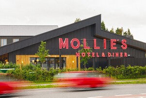Un edificio moderno con un letrero que dice "Mollie's Motel & Diner".