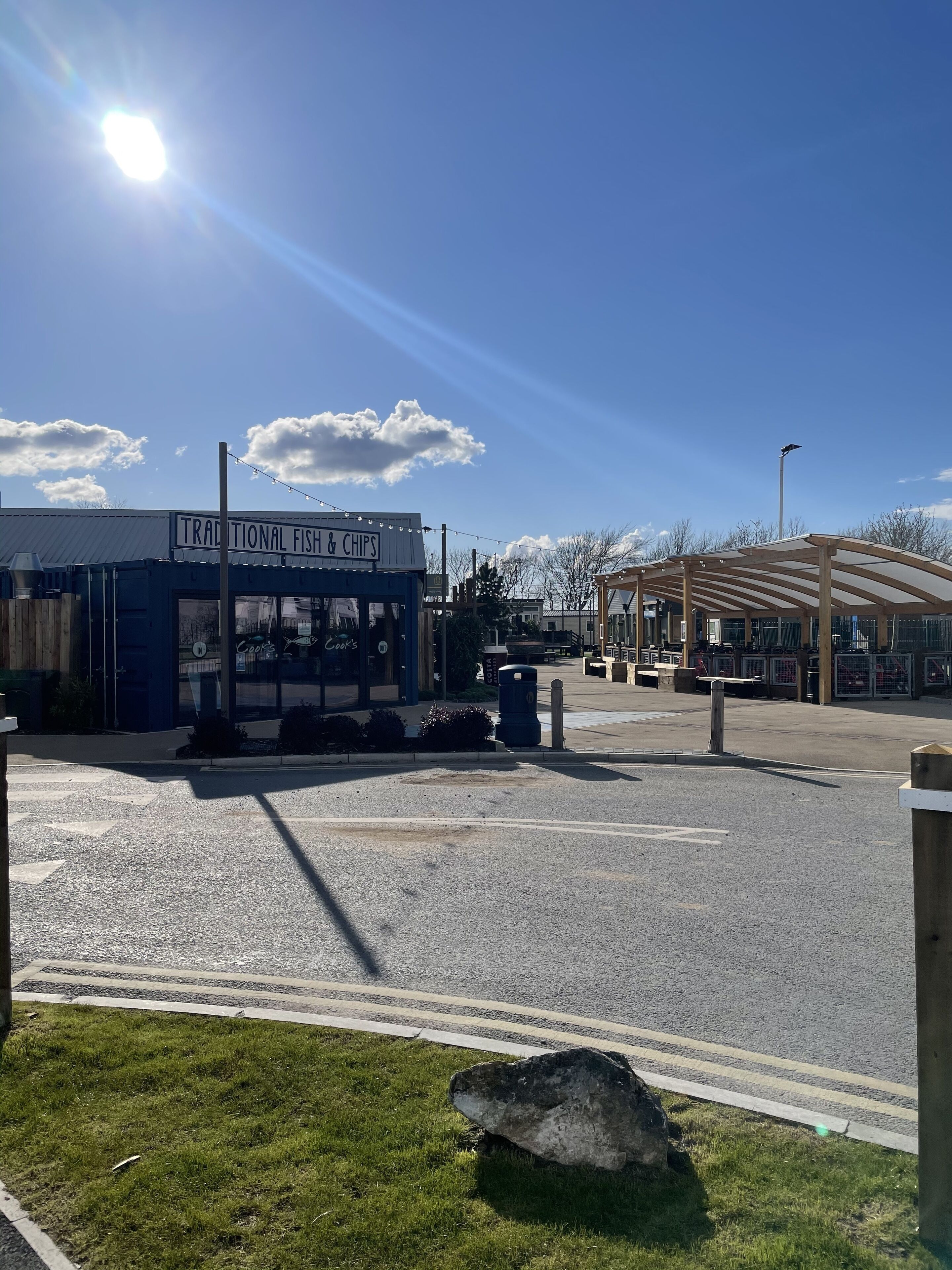 A parking lot with a building labeled "Traditional Fish & Chips."