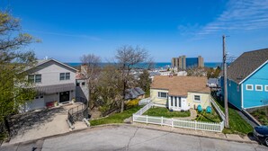 Un quartier résidentiel avec des maisons, une clôture blanche en bois et une vue sur l’océan.