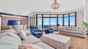A spacious living room with a large sofa, two armchairs, a coffee table, and a balcony with a view. - New to the Rental Market, Newly Owner, Newly Renovated!!! (Orange Beach)