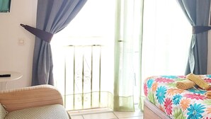 Una camera da letto con un letto, una sedia e una finestra con tende.