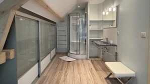 Un baño moderno con ducha, lavabo y espejo.