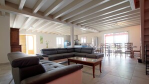 A spacious living area with a large sectional sofa, a coffee table, and a kitchen in the background. - BORDAZARRIA - JUXUE - Gîte (JUXUE)