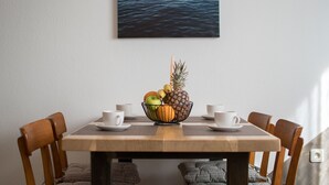 A dining table with a fruit bowl, white cups, and a view of water. - New apartment Marin Punta-Umag near the sea (Umag)
