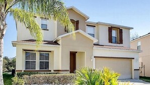 A two-story house with a garage, a front door, and a small porch. - Extravagant Resort styles  5 bedrooms / 5 baths/ pool and hot tub (Davenport)