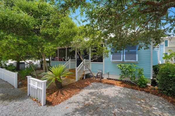 A house with a porch, a staircase, and a gravel driveway. - Located Across From Beach in Seaside, Wrap-Around Porches + 2 Adult Bikes! (Santa Rosa Beach)