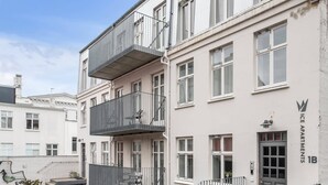 A multi-story residential building with balconies, a staircase, and a gated entrance. - Standard Apartment Su (Reykjavík)