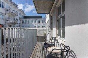 A balcony with a metal railing, two chairs, and a small table. - ICE Superior One Bedroom Apartment (Reykjavík)