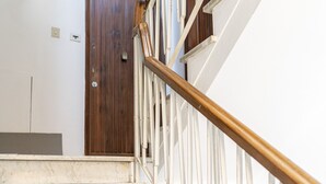 A staircase with marble steps and a wooden handrail. - La Lu Cozy Rooms 2 (Pisa)