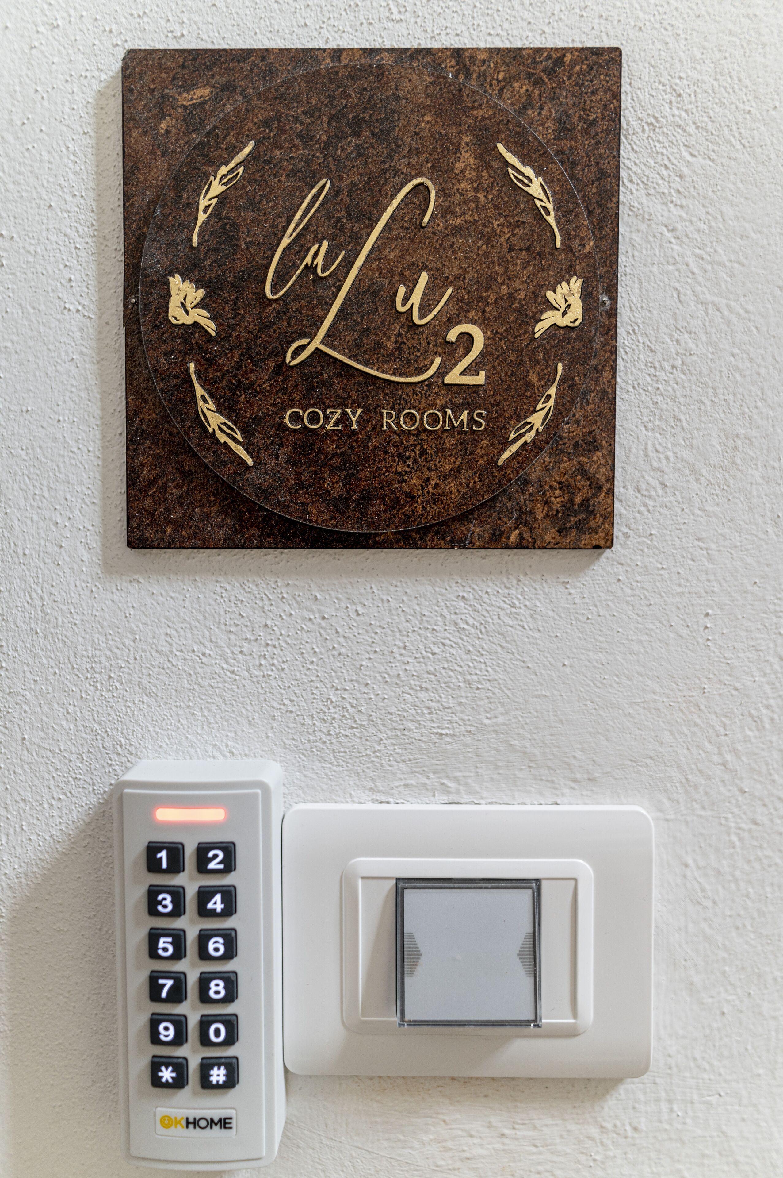A wall-mounted keypad and a sign for 'Lu2 Cozy Rooms'.