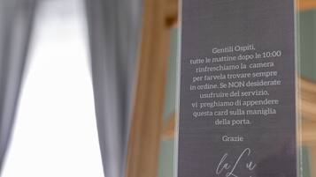 Un cartel con indicaciones en italiano, colgado de un caballete de madera.