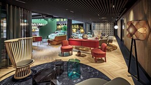 A modern interior with a central seating area, a bar, and a reception desk. - The Florian Amsterdam Schiphol Airport, WorldHotels Crafted (Hoofddorp)