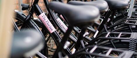 Una hilera de bicicletas con un cartel rosa sujeto a una de ellas.