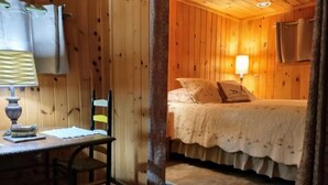 Una habitación de madera con una cama, un escritorio y una silla.