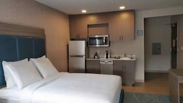 Ein Hotelzimmer mit Bett, einer Küchenzeile und einem Badezimmer.