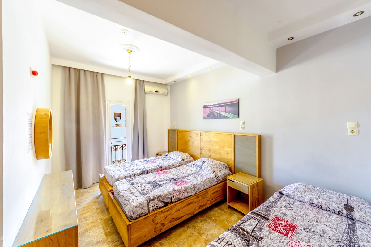 A bedroom with a wooden bed, a bedside table, a mirror, and a painting on the wall.