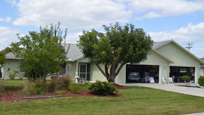 Un bâtiment d’un seul étage, doté d’un garage, d’une pelouse bien entretenue et d’un arbre à l’avant.