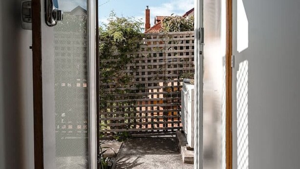 A narrow entryway with a sliding glass door leading to a balcony.