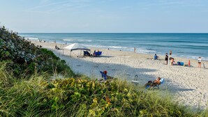 A beach with people, tents, and beach chairs. - Off Season - Huge Savings - Heated Pool (Indialantic)