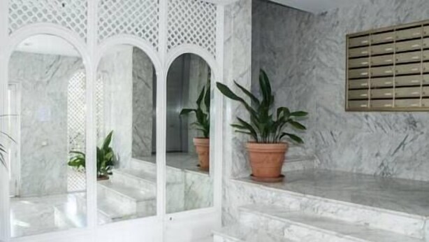 A marble staircase with three arches leading to a landing.