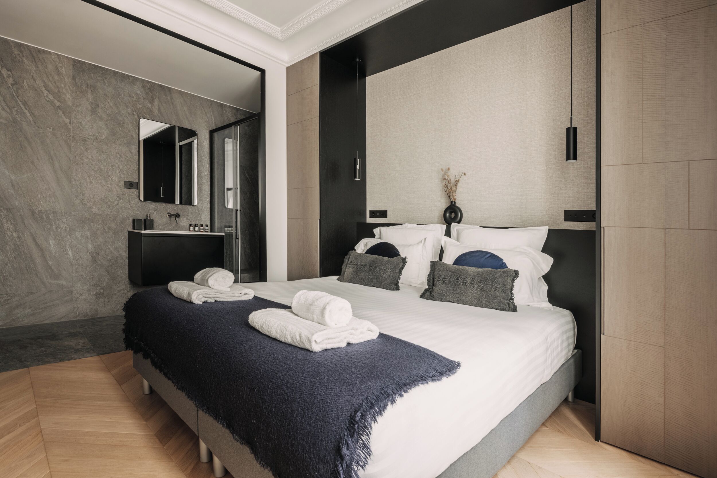 Ein modernes Schlafzimmer mit einem großen Bett, einem integrierten Schminktisch und einem Spiegel.