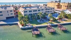 An aerial view of a coastal hotel with multiple buildings, a swimming pool, and a beach in the background. - Beautiful waterfront condo on intercoastal in Treasure Island (Treasure Island)