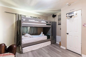 A bunk bed room with a door labeled "VICTORY" and a basketball hoop on the wall.