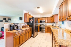 Eine moderne Küche mit Holzausstattung, Edelstahlgeräten und Granit Arbeitsplatten.
