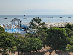 A beach resort with a swimming pool, a lifeguard tower, and beach umbrellas. - Hotel Internazionale (Cesenatico)