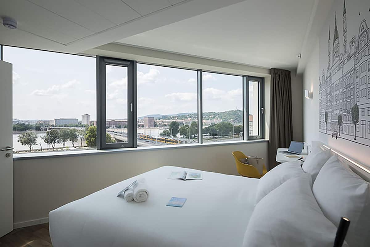 Vierpersoonskamer, uitzicht op rivier | Een kluis op de kamer, een bureau, geluiddichte muren, gratis wifi