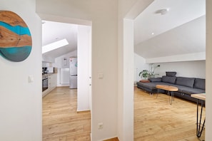 A modern apartment with a kitchen, dining area, and living room.