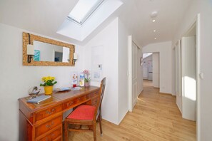 Work in comfort with a desk and chair, plus a mirror and potted plant.
