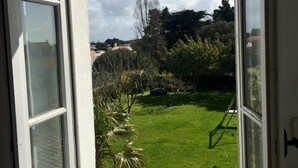 A view from a window with a clear sky and a well-maintained lawn. - Au Coeur du Banzeau (Noirmoutier-en-l'Île)