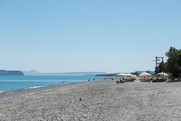Relax on the beach with comfortable sun loungers and umbrellas.