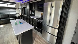 Una cocina compacta con refrigerador, estufa y lavamanos.