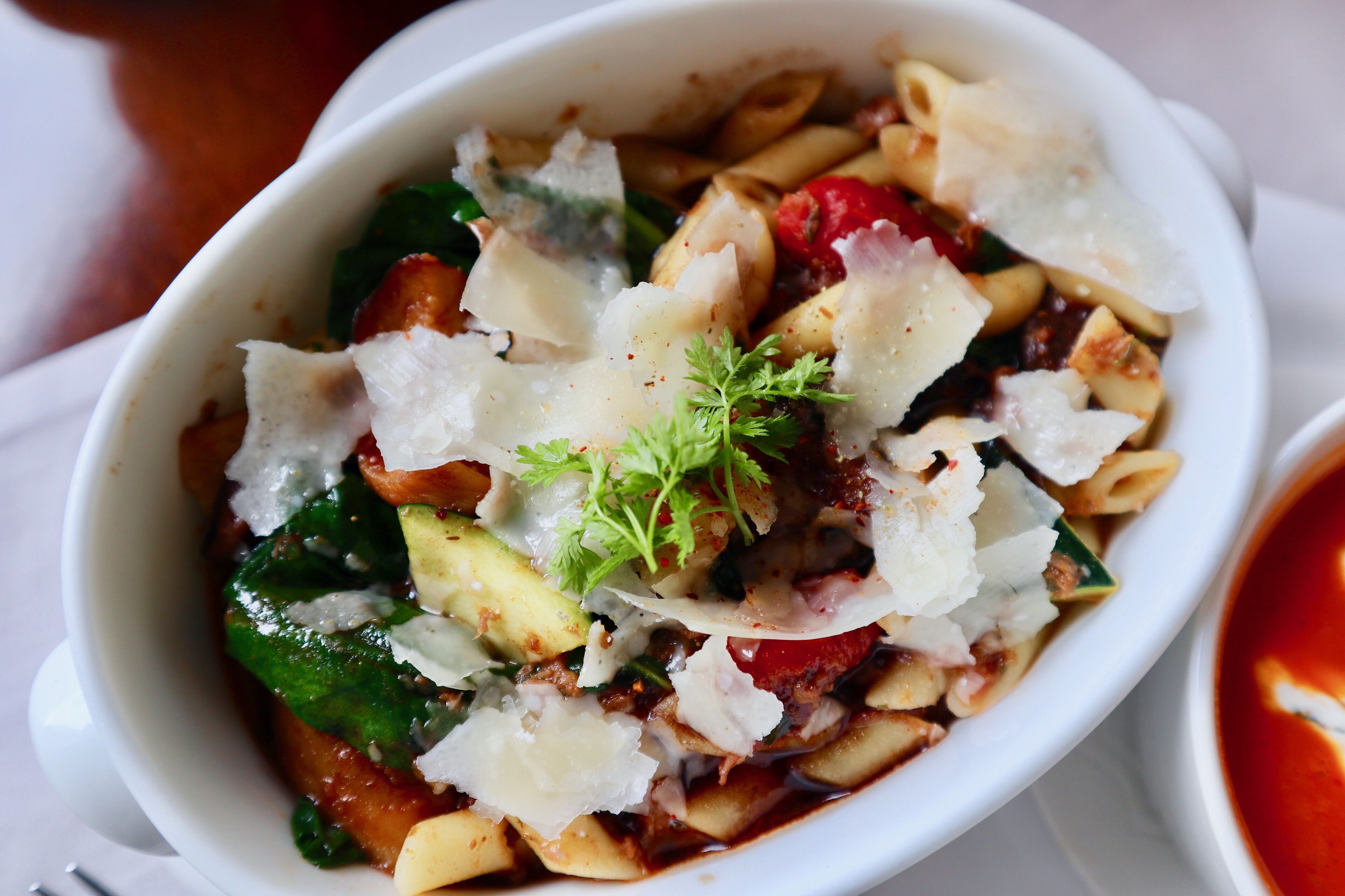 Eine Schüssel Pasta mit Gemüse und Käse.