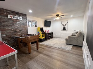 Relax in this stylish living room with a foosball table, arcade machine, and flat-screen TV.