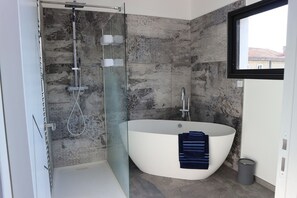 Bathtub, hair dryer, towels, toilet paper