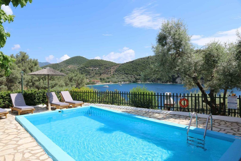 Una piscina al aire libre, sillones reclinables de piscina