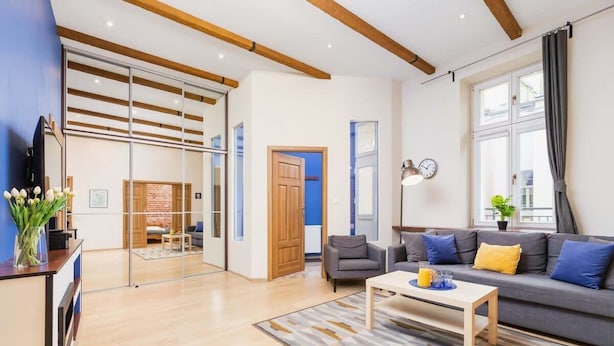 Un salon moderne avec un canapé, une table basse et une cloison en verre.
