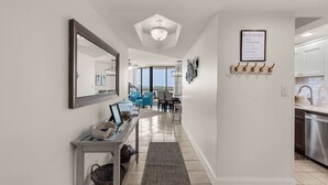 A modern interior with a hallway leading to a dining area and kitchen.