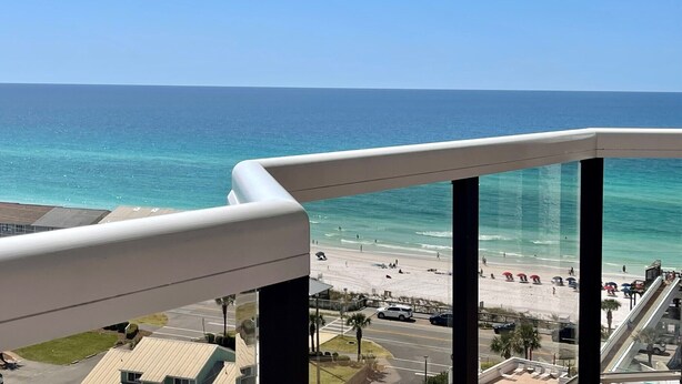 A balcony with a view of a beach and ocean.
